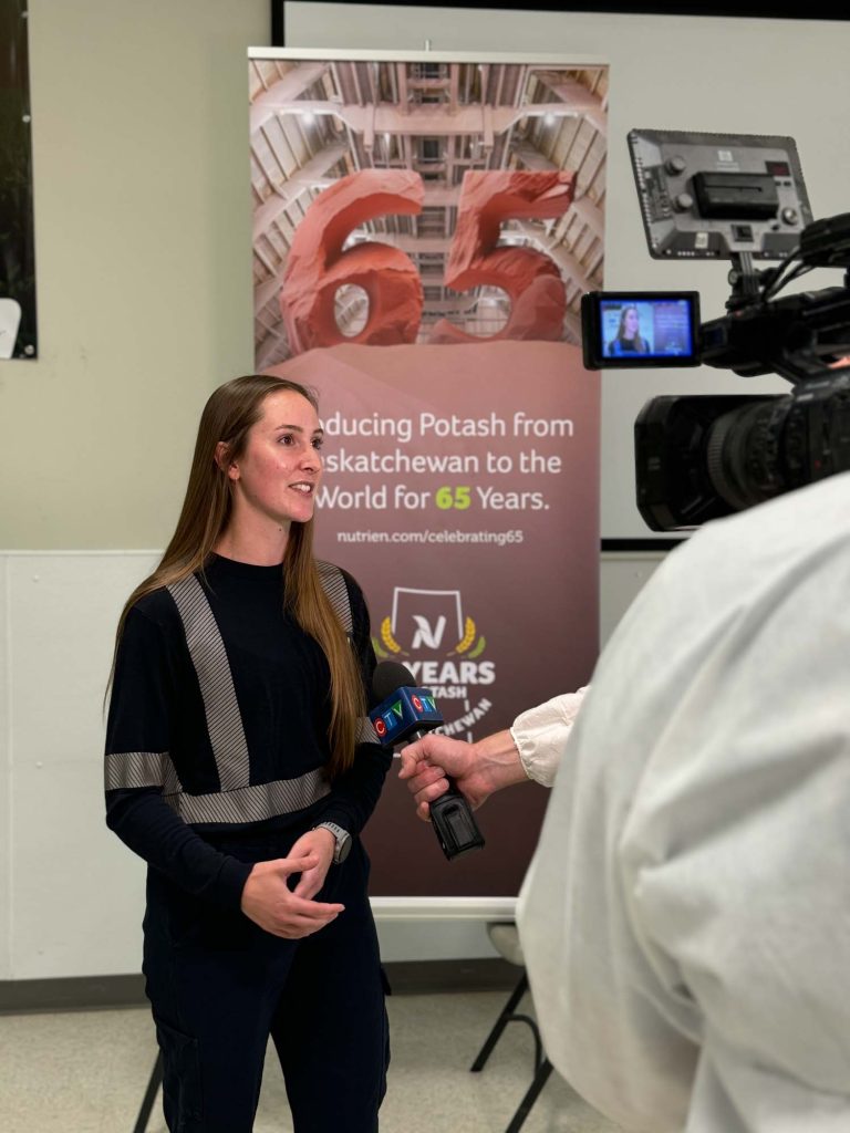 A female employee of Nutrien speaking to a television camera. 